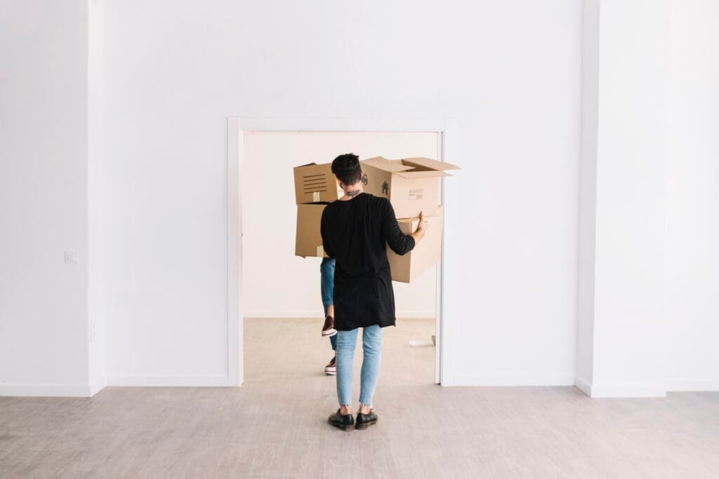 Personne portant des cartons lors d'un déménagement pour un état des lieux de sortie, expert immobilier