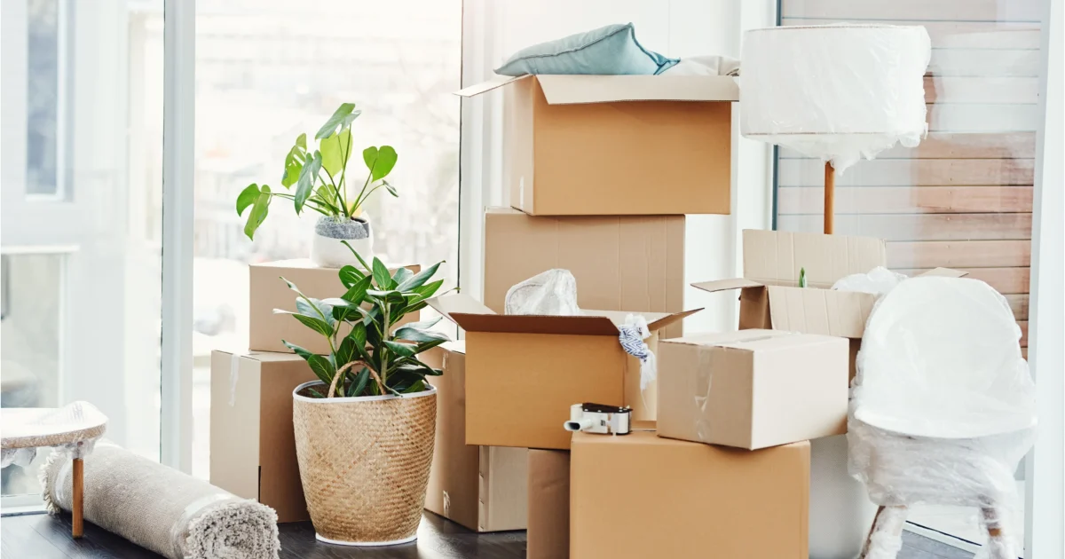 Quand doit se faire l’état des lieux de sortie ? Illustration de cartons de déménagement et de meubles emballés, prêts pour la fin d’un bail.